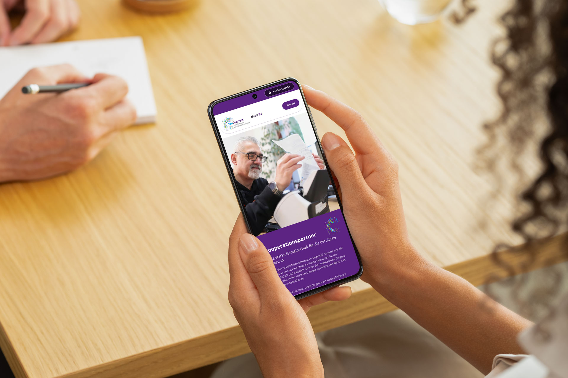 Responsive Darstellung der barrierefreien JobConnect-Website auf einem Smartphone. Zu sehen ist ein älterer Mann bei der Arbeit, die Seite informiert über Kooperationspartner. Webdesign von Grafikstudio Carreira für die Diakonie Stiftung Salem.