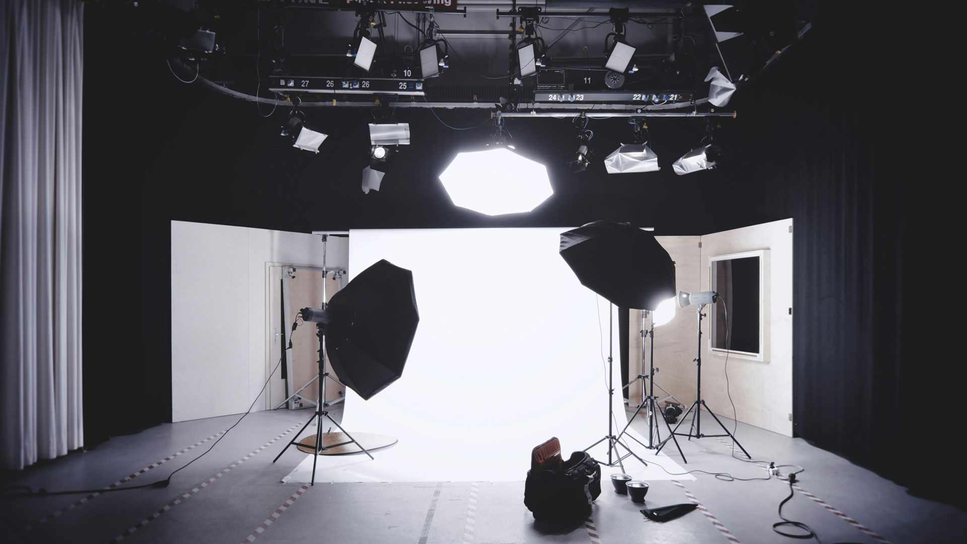 Fotostudio mit professionellem Licht-Setup für barrierefreies Marketing: Mehrere Softboxen, Studiolampen und Scheinwerfer sind auf eine helle, weiße Hintergrundfläche ausgerichtet. Das Setup steht in einem ruhigen Studio-Raum und symbolisiert professionelle, zugängliche Foto- und Medienproduktion für inklusive Kommunikation.