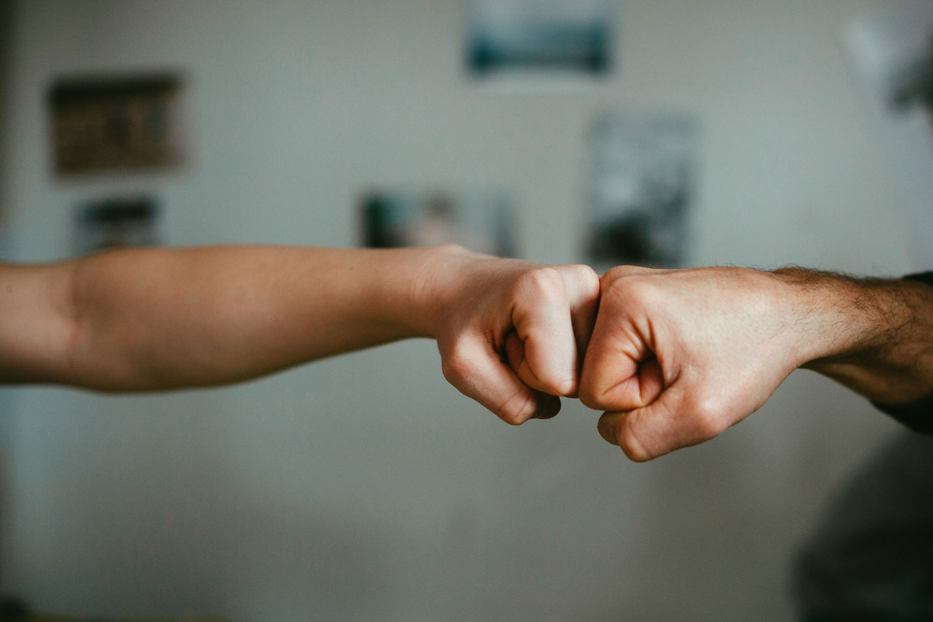 Zwei Personen stoßen sich freundschaftlich mit der Faust ab – ein Symbol für Partnerschaft und gegenseitiges Vertrauen. Das Bild begleitet ein Interview mit Thomas Matic über strategische Inklusion und barrierefreie Unternehmenskultur.